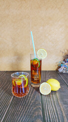 Close-up of lemon cocktails on wooden table, drinking straw, marble background