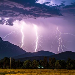 Electric storm jagged bolts of lightning strike behind rolling hills, framed by a dark sky. Field and trees sit below