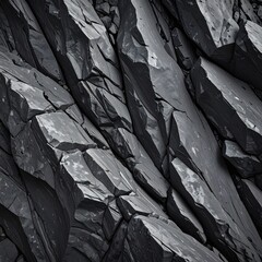 Close-up of stark gray basalt columns, showcasing geometric fractures, textures, and shadows creating a dramatic and angular rock formation
