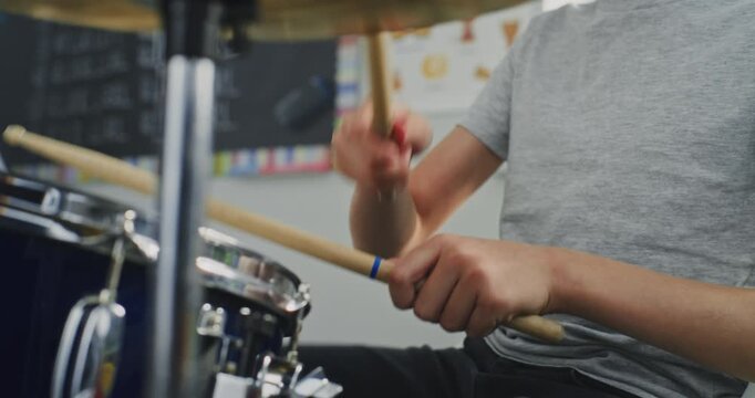Close Up Shot of Primary School Boy Practicing Drums in Music Class, Dreaming to Become Drummer. Talented Young Young Musician Playing Drum Set During Percussion Lesson. Rhythm Education, Musical Art.