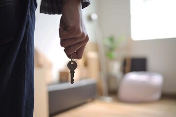 Person Holds New House Key Symbolizing Fresh Start in Room With Moving Boxes