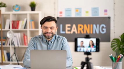 Value for Digital Nomad A smiling man engages in online learning with a laptop and camera setup in a tidy workspace.