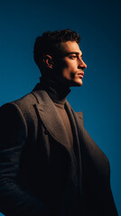 Stylish Male Model in Dramatic Side Lighting Against Blue Background