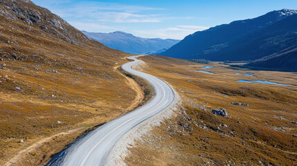 Winding mountain road through scenic landscape, surrounded by hills and valleys, showcasing natural beauty and tranquility