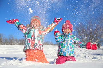 little girls playing on snow in winter time