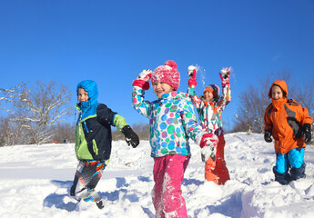 Group of children playing on snow in winter time