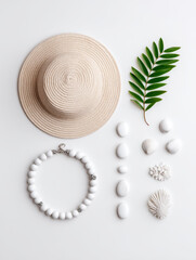 Straw hat, white beaded necklace, green leaf, seashell, coral, and stone arranged on white background, creating boho summer flatlay with calm and natural vibe