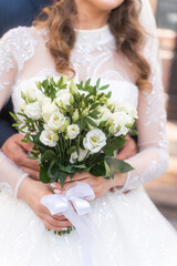 Close-up wedding couple bride and groom walk hand in hand through a pine forest, sunlight filtering through the trees