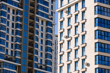 Fototapeta premium Modern luxury residential flat. Modern apartment building on a sunny day. Apartment building with a blue sky. Facade of a modern apartment building.