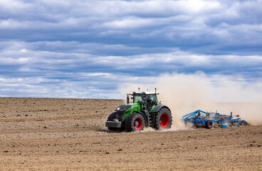 Obraz premium Agricultural plows are plowed to wait for the farming season. Farmer with tractor seeding.