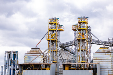Modern Granary elevator. Silver silos on agro-processing and manufacturing plant for processing drying cleaning and storage of agricultural products, flour, cereals and grain.