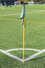 Soccer field corner flag stands ready on a sunny day in a vibrant sports complex
