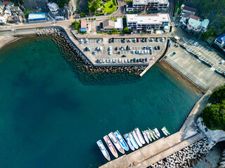 中木港の港町のドローン撮影。
家並みや墓地、満車の駐車場、沖にはヒリゾ浜や大根島、沖磯などが見える。
静岡県伊豆半島賀茂郡南伊豆町中木ヒリゾ浜-2025年

