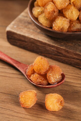 Golden Dried Fruit in Wooden Spoon and Bowl on Rustic Wood Background