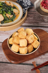 Fried Tofu Puffs with Spinach Soup - Traditional Asian Vegetarian Dishes on Wooden Table