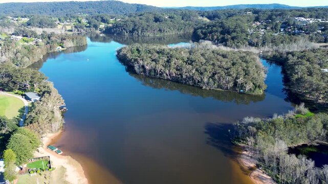 Drone aerial landscape of Avoca Beach lake and lagoon river waterway system surrounded by trees bushland and natural wilderness with small island Central Coast Australia nature travel tourism outdoors
