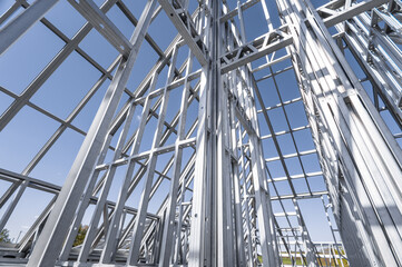 Obraz premium Building in construction, Metallic structure against a clear sky. New residential construction home metal framing.