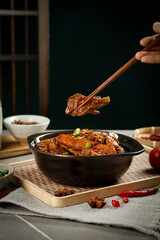 Wood-fired stewed goose in iron pot - traditional braised poultry dish with chopsticks