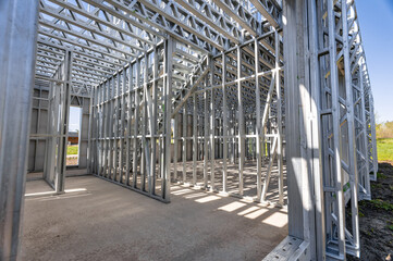 New home under construction using steel frames against cloudy sky. Metal frame of a new modern house. No people. Copy space