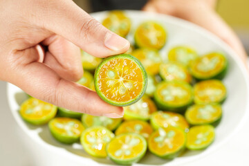 Fresh Kumquat Slices from Guangxi Hainan - Hand Holding Small Orange Citrus Fruit with Clear Flesh and Seeds