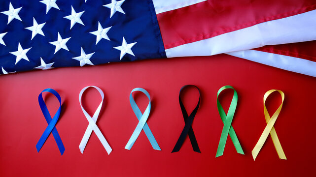 Awareness Months ribbon colors on red background with american flag - Powered by Adobe