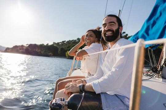 Happy couple enjoying sailing on recreational boat - Powered by Adobe
