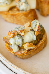 crispy crostini topped with fresh pear slices and creamy blue cheese. Perfect for illustrating elegant fall appetizers, holiday party snacks