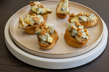 crispy crostini topped with fresh pear slices and creamy blue cheese. Perfect for illustrating elegant fall appetizers, holiday party snacks