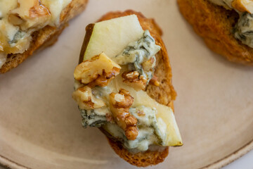 crispy crostini topped with fresh pear slices and creamy blue cheese. Perfect for illustrating elegant fall appetizers, holiday party snacks