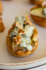crispy crostini topped with fresh pear slices and creamy blue cheese. Perfect for illustrating elegant fall appetizers, holiday party snacks