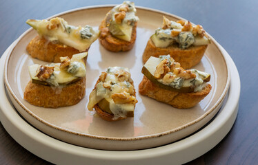 crispy crostini topped with fresh pear slices and creamy blue cheese. Perfect for illustrating elegant fall appetizers, holiday party snacks