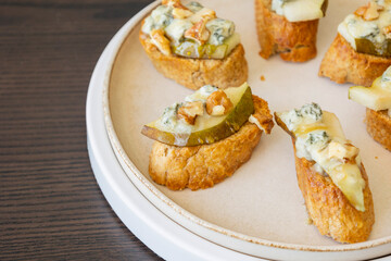 crispy crostini topped with fresh pear slices and creamy blue cheese. Perfect for illustrating elegant fall appetizers, holiday party snacks