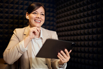 Professional Woman Smiling While Using a Tablet in an Acoustic Office Space