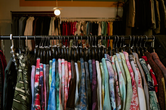 Colorful vintage tie-dye t-shirts hanging on rack in fashion store
