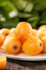 Fresh Loquat Fruits from Panzhihua Sichuan China on White Plate with Green Alpine Background