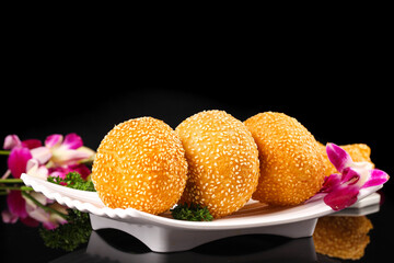 Golden Fried Sesame Balls Chinese Dumplings with Sesame Seeds on White Plate