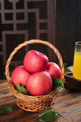 Fresh Red Fuji Apples from Luochuan in Wicker Basket on Rustic Wooden Table