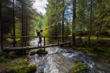 Obraz premium Active woman crossing bridge over Ponor creek