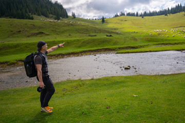 Hiker pointing in Ponor Meadow Romania