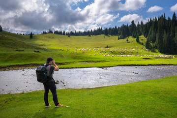 Hiker photographing Ponor Meadow Romania