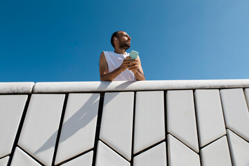 Person holding phone after morning run at Lisbon Maat in summer