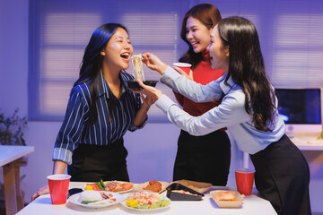 Coworkers eating asian takeaway food together in office