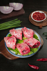 Fresh Rabbit Heads with Traditional Chinese Cooking Ingredients on Dark Wooden Background