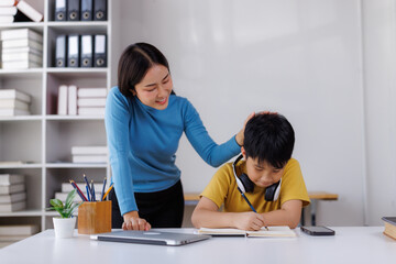 Asian teacher encouraging student during lesson in classroom