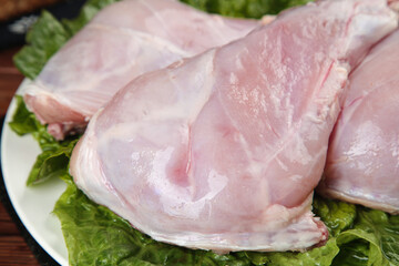 Fresh Raw Rabbit Meat Foreleg Cuts on Lettuce Leaves Ready for Cooking