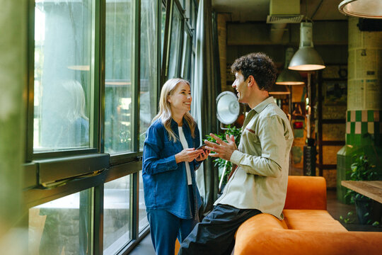 Business colleagues discussing at office in casual clothing by window