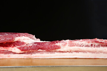 Raw Pork Belly Cut with Thick Fat Layers on Wooden Cutting Board