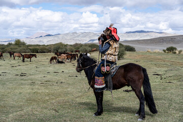 A Mongolian eagle hunter, a berkutchi, prepares to hunt with his bird on a September day in Mongolia.