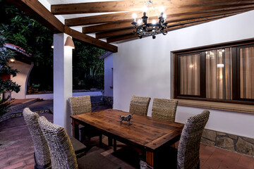 Evening view of the Mediterranean-style terrace with illuminated windows and garden features.