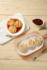 Xiamen Style Steamed Dumplings with Asparagus Filling and Soy Sauce on Wooden Table